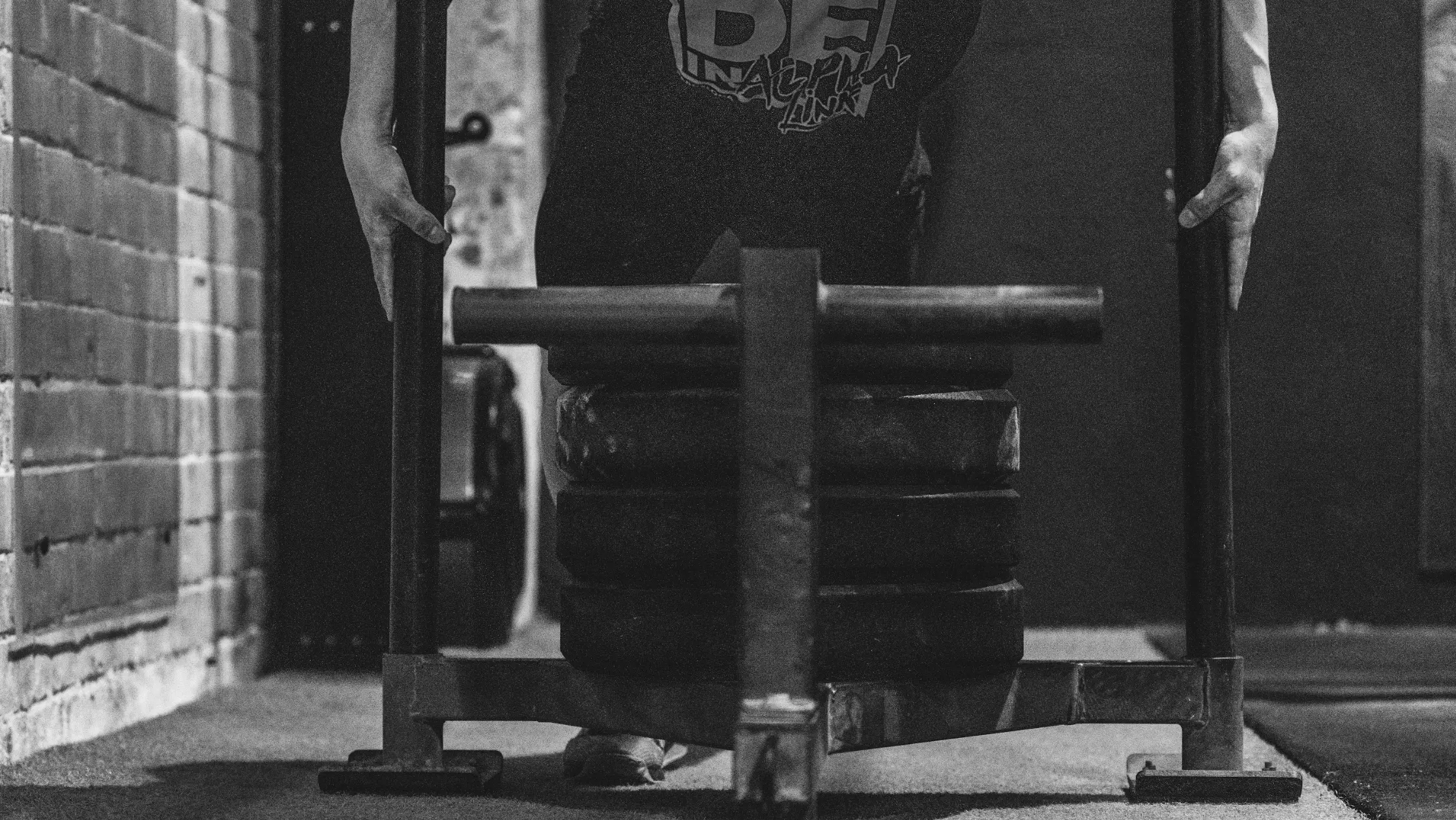 Persona levantando peso en gimnasio, esfuerzo físico para competición HYROX.