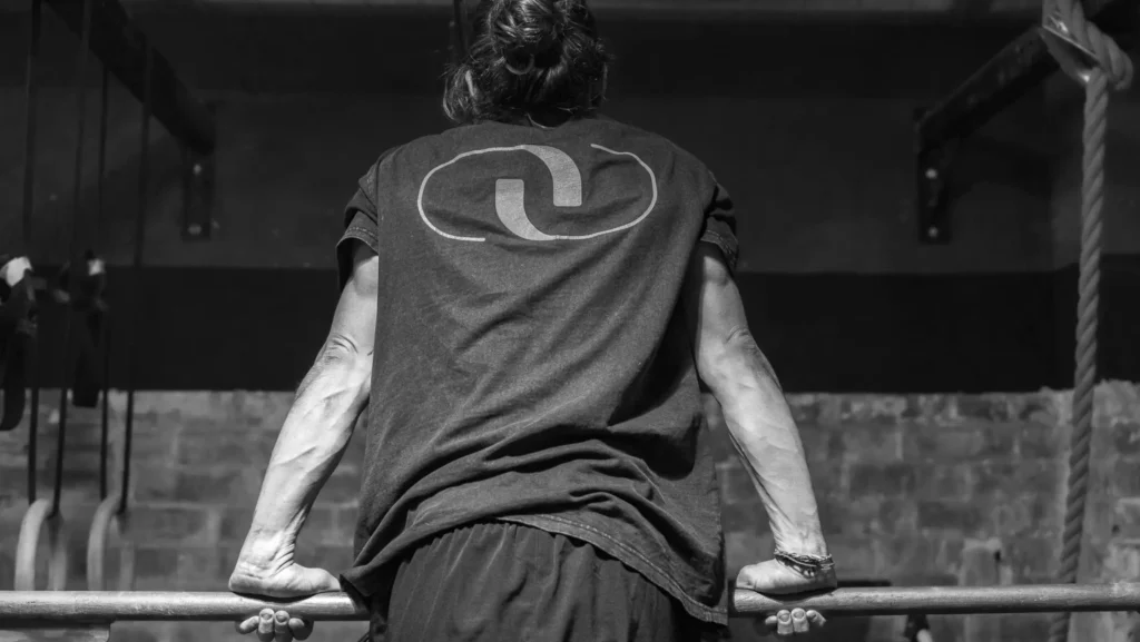 Atleta realizando fondos en barra durante entrenamiento de CrossFit.